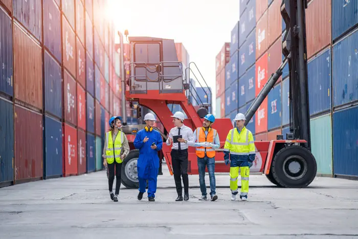 a group of employees walking with manager in a shipping yard