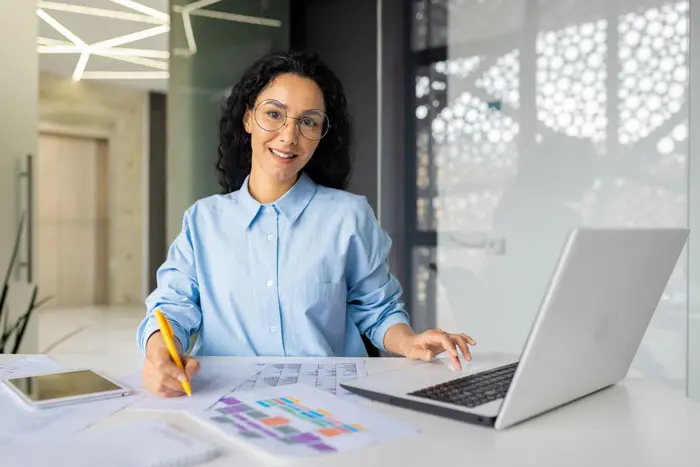 a young female on her computer and taking notes