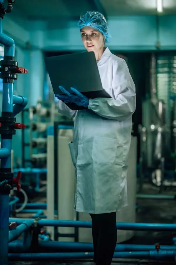 a woman with a white lab coat and monitor