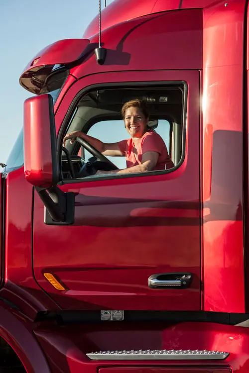a woman driving a semi-truck